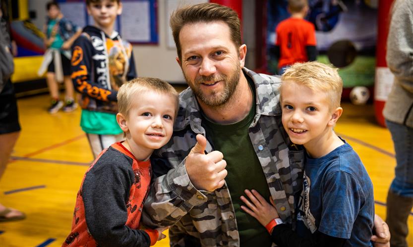 A father and his two sons smile